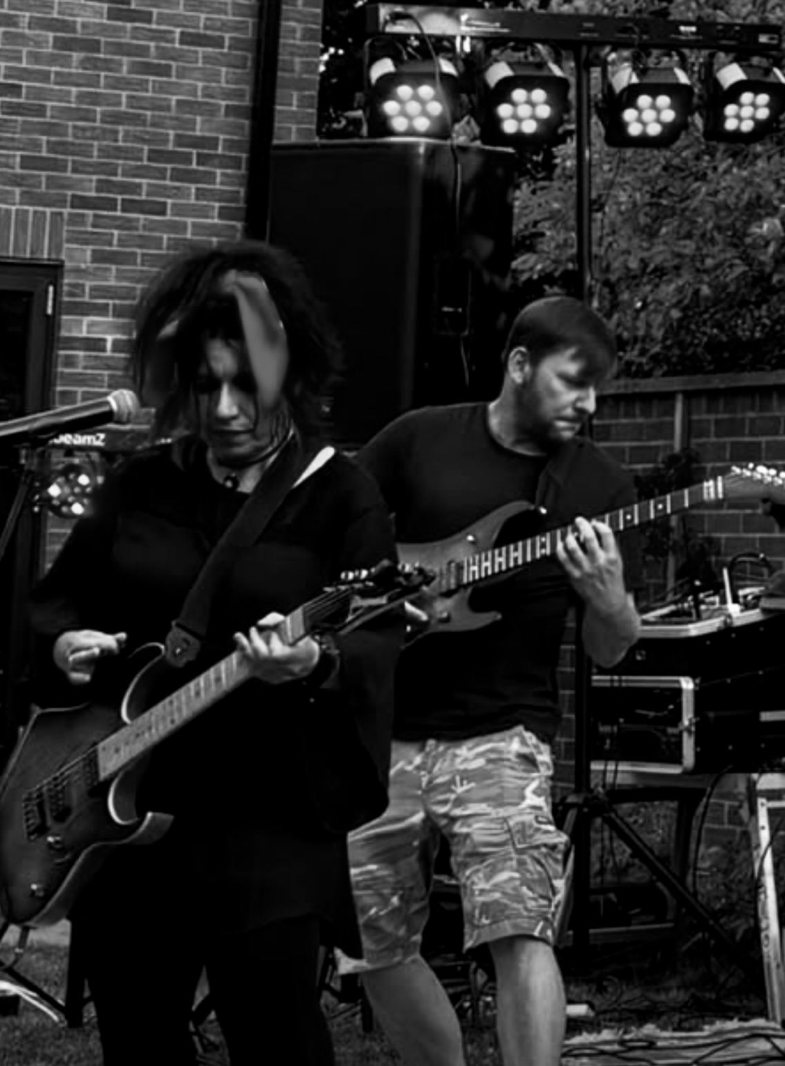 Guitarists performing at a garden gig