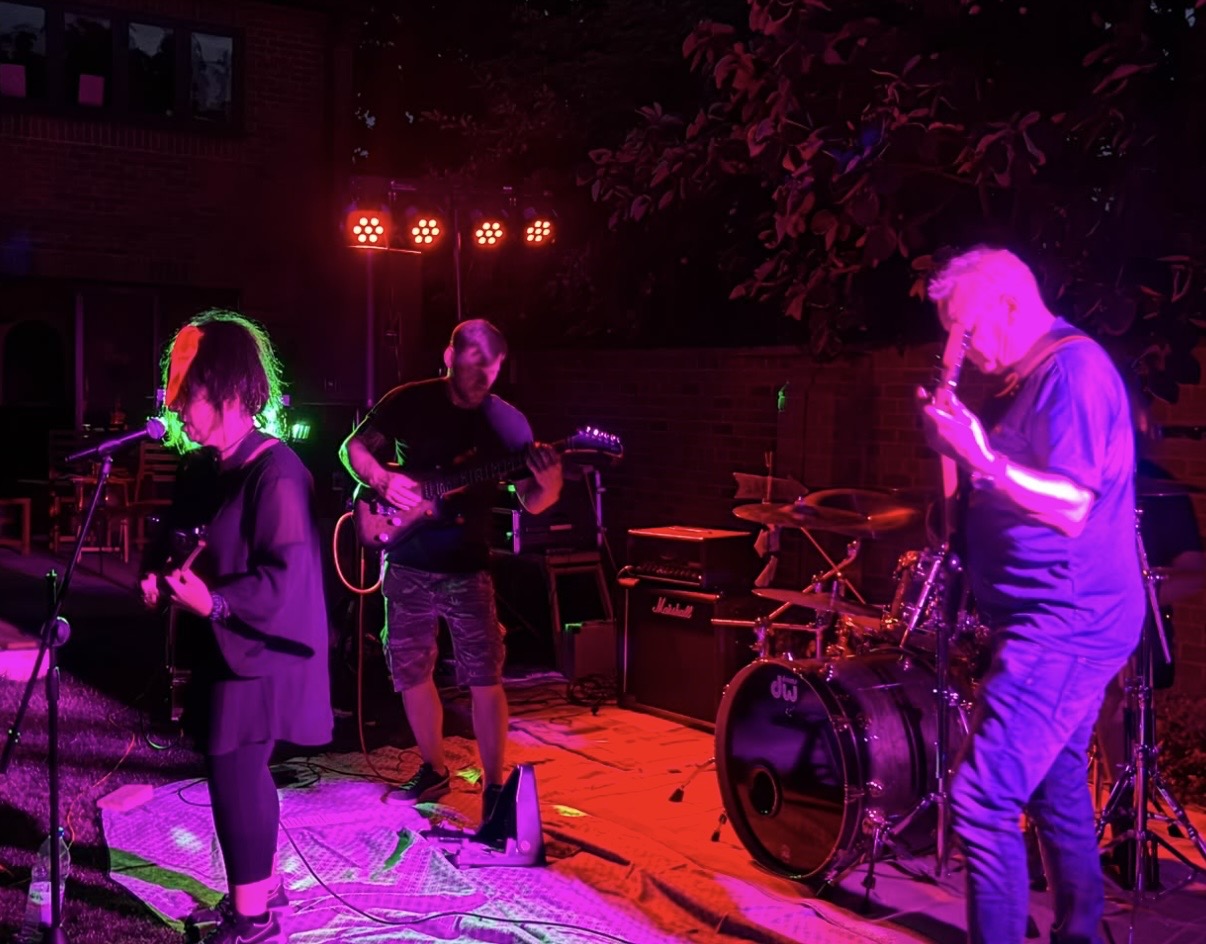 Band performing under red and purple lighting