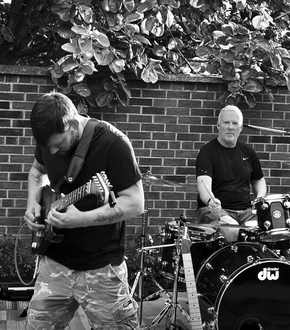 Guitarist and drummer rehearsing outdoors