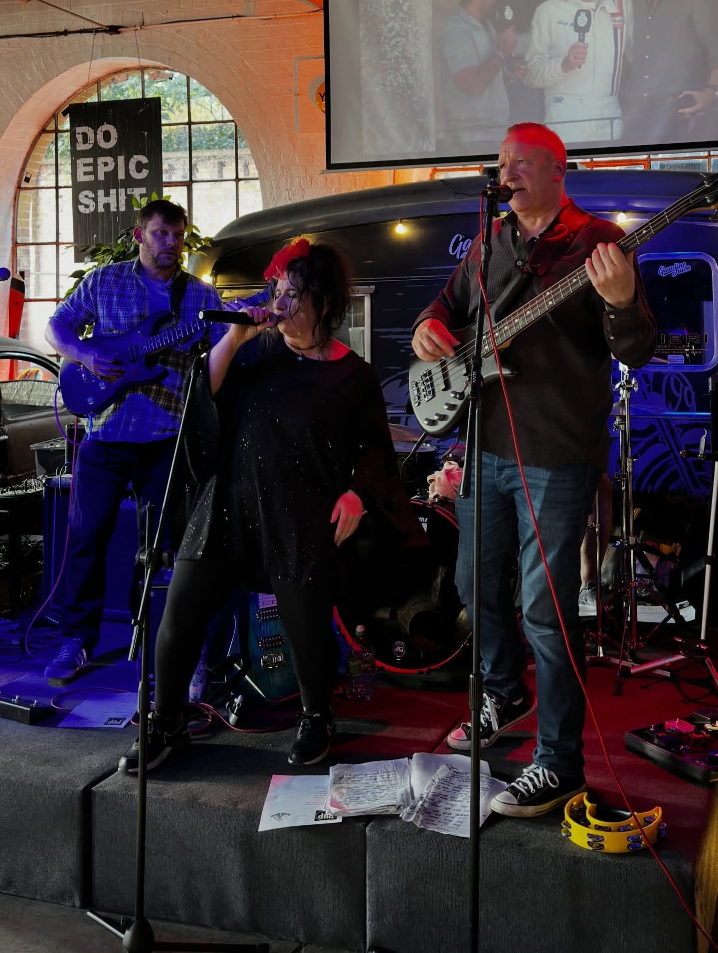Band performing live indoors with vocalist and bassist